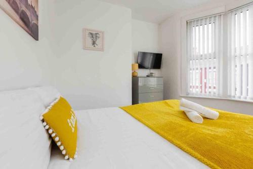 a white bedroom with a yellow blanket on a bed at Modern Family Home With Parking-Pem in Liverpool