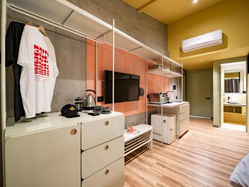 uma cozinha com armários brancos e uma televisão num quarto em The Somos Flats Provenza em Medellín