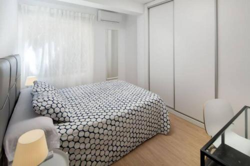a white bedroom with a bed and a couch at Garcia Briz by Bossh! Apartments in Málaga