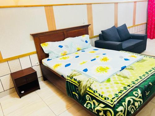 a bedroom with a bed and a chair in it at RESIDENCE AMAR in Douala