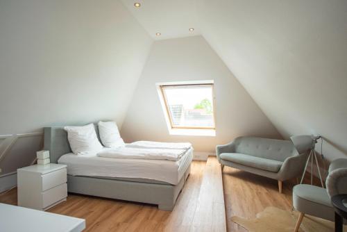 a bedroom with a bed and a chair and a window at Großzügiges Ferienhaus an der Ostsee in Scharbeutz