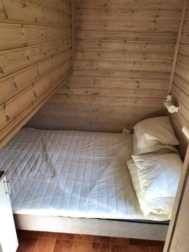 Cama en habitación con pared de madera en Stockholm Swecamp Flottsbro, en Huddinge