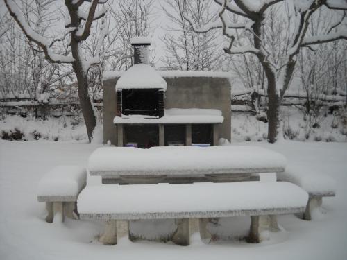 two benches covered in snow in a park at Mas Meya in Puigcerdà