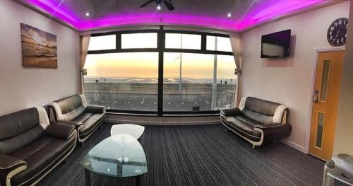a living room with couches and a large window at Funky Towers in Blackpool