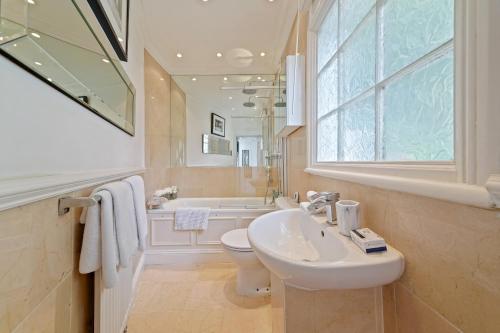 a bathroom with a sink and a toilet and a tub at Finest Retreats - Hanover Mews in London