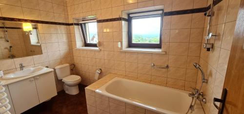 een badkamer met een bad, een toilet en een wastafel bij Sierra u Beaty in Buczkowice
