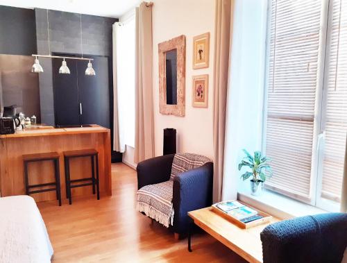 un salon avec une chaise et une table dans l'établissement Kalu Studio 8 - Studio cosy Centre médiéval Sarlat, à Sarlat-la-Canéda