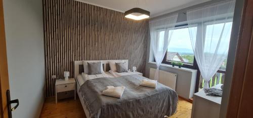 een slaapkamer met een bed en een groot raam bij Sierra u Beaty in Buczkowice