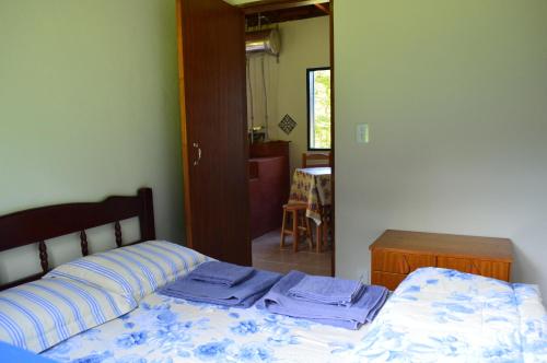 a bed with blue and white sheets in a bedroom at Chalés Serrinha do Papagaio in Aiuruoca