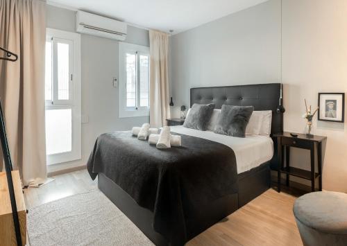 a bedroom with a large bed with a black blanket at Stay Unique Apartments Aprestadora in Hospitalet de Llobregat