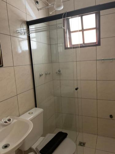 a bathroom with a shower and a toilet and a sink at Pousada Irmãos do Mar in Ilhabela