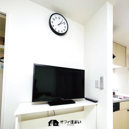 a clock on the wall above a tv in a room at （B8）NEW OPEN 快適2名まで滞在可☆サービスアパ―トメントSAPPORO南8条B8 in Sapporo