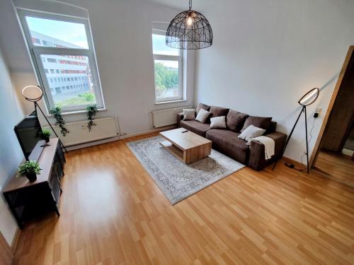 ein Wohnzimmer mit einem Sofa und einem Tisch in der Unterkunft YourFavoriteBed Designwohnung Nähe Zentrum und Klinikum in Plauen