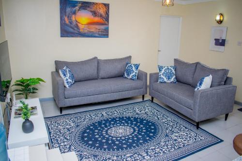 a living room with two couches and a rug at Arabella Alpha - Modern & Homely 1-Bedroom Apartment in Karen in Karen