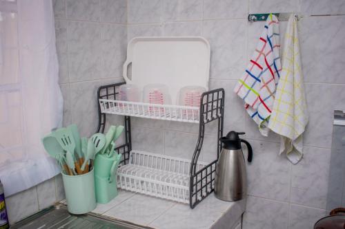 a shelf with utensils on a counter in a kitchen at Arabella Suites - Karen in Karen