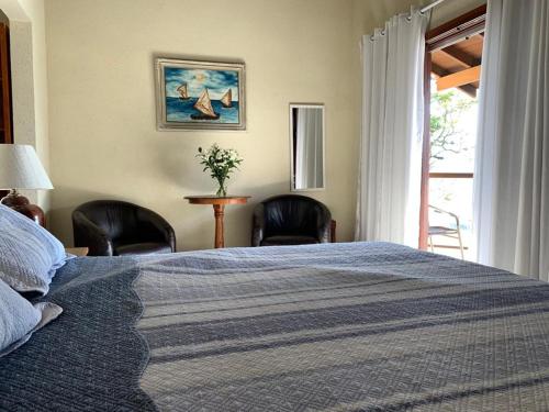 - une chambre avec un lit, 2 chaises et une fenêtre dans l'établissement Pousada Irmãos do Mar, à Ilhabela