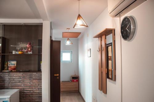 un pasillo que conduce a una cocina con un reloj en la pared en Villa 38 Silviu Apartment, en Bucarest