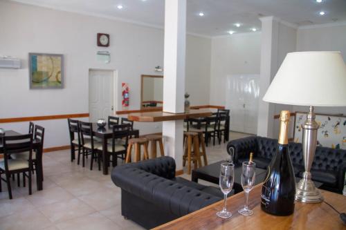un comedor con sillas y una mesa con copas de vino en Apart Hotel Savona en Capilla del Monte