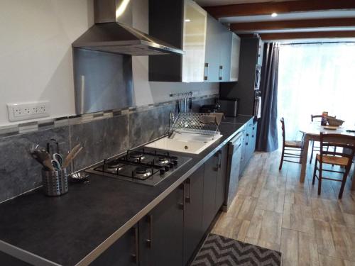 a kitchen with a sink and a stove top oven at Gîte de Fanny du Moulin de Tartay en Avignon in Avignon