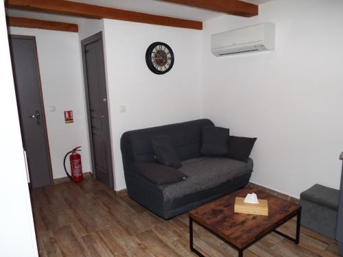 a living room with a couch and a table at Gîte de Fanny du Moulin de Tartay en Avignon in Avignon
