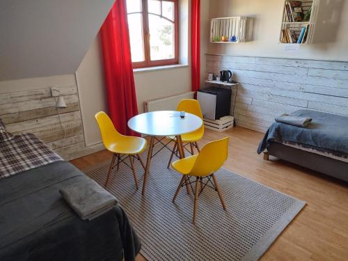 1 dormitorio con 1 cama, mesa y sillas en Apartamenty Zielona Góra, en Zielona Góra