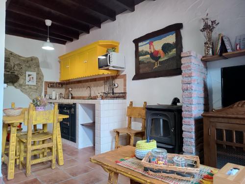 a kitchen with a table and a stove at La Castañar - La Vallicuerra Casas Rurales in Mieres