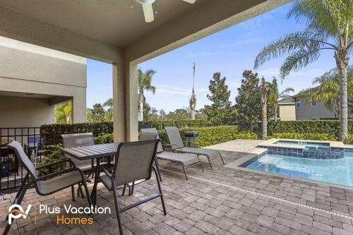 un patio con tavolo, sedie e piscina di 331-Luxury Villa wPOOL & SPA By Disney a Orlando