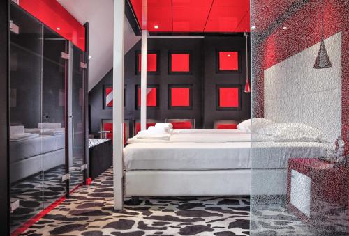 una camera con letto bianco e illuminazione rossa di Hotel Lent superior a Maribor