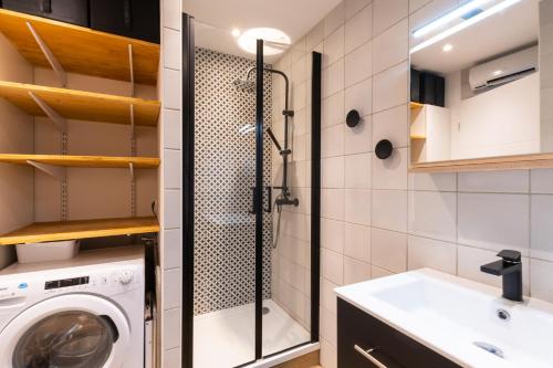 a bathroom with a washing machine and a sink at Au Paradis bleu - Parking privé - Literie confortable - Vue port - Plage à 5 min in La Grande-Motte