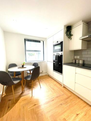 a kitchen with a table and chairs in a room at Prosper House Apartments in Norwich