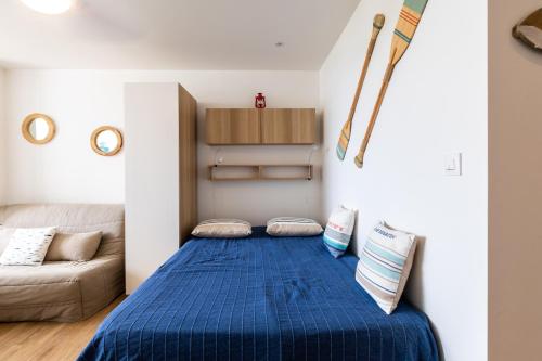 a bedroom with a blue bed and a couch at La Paradis bleu - Parking privé - Literie confortable - Vue port - Plage à 5 min in La Grande Motte