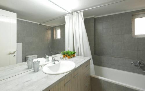 a bathroom with a sink and a tub and a mirror at PanOrama View, Nilie Hospitality MGMT in Thessaloniki