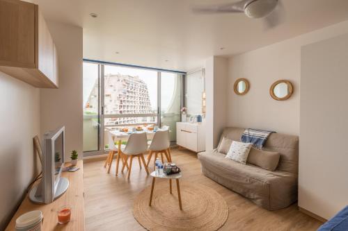 un salon avec un canapé et une table dans l'établissement Au Paradis bleu - Parking privé - Literie confortable - Vue port - Plage à 5 min, à La Grande Motte
