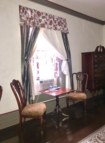 a dining room with a table and chairs and a window at Belmont Inn in Shelbyville