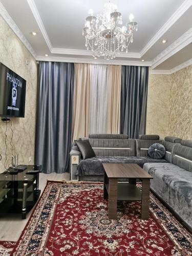 uma sala de estar com um sofá e uma mesa em Aisha em Bishkek