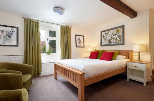 a bedroom with a bed and a chair and a window at Easington Guest House in Banbury