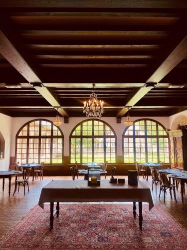 a large room with tables and chairs and a chandelier at Château de Fontager in Serves-sur-Rhône