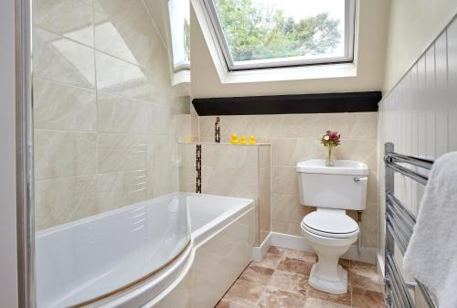 uma casa de banho com uma banheira, um WC e uma janela. em Easington Guest House em Banbury