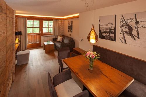 a living room with a table and a couch at Das alpine Lifestyle Berghotel Madlener in Damuls