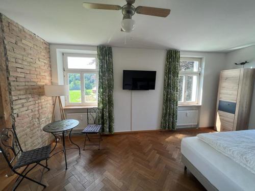 sypialnia z łóżkiem, stołem i telewizorem w obiekcie Auszeit im Bad Diezlings w mieście Hörbranz