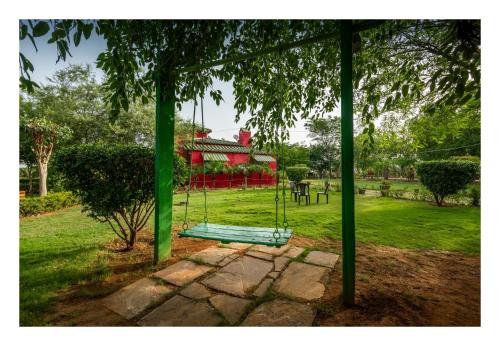 a swing hanging from a tree in a park at An Authentic Village Farm in Jhānsi