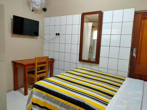 a bedroom with a bed and a table and a mirror at Golden Days Lodge in Livingstone