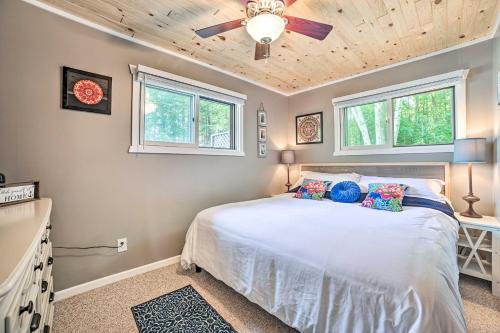 - une chambre avec un lit, un ventilateur de plafond et des fenêtres dans l'établissement Lakefront Hideaway with Dock, Kayaks, Fire Pit!, 
