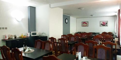 a dining room with chairs and tables and a clock at Penzion Stavař in Vrbno pod Pradědem