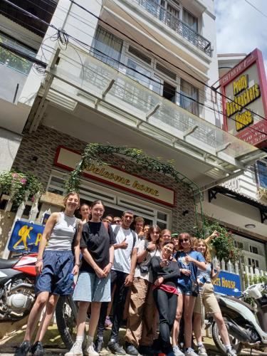 a group of people standing in front of a building at Pretty Backpackers House in Da Lat
