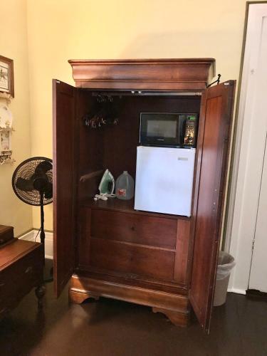 a microwave in a wooden cabinet with a tv in it at Belmont Inn in Shelbyville