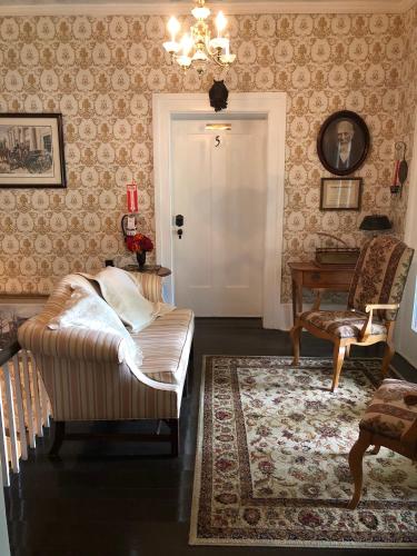 a living room with a bed and a chandelier at Belmont Inn in Shelbyville