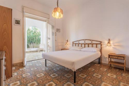 ein Schlafzimmer mit einem Bett und einem großen Fenster in der Unterkunft Villa Carlotta Vicino Al Mare in Carini