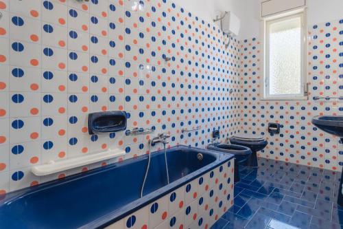 ein Badezimmer mit einer blauen Badewanne und einem WC in der Unterkunft Villa Carlotta Vicino Al Mare in Carini