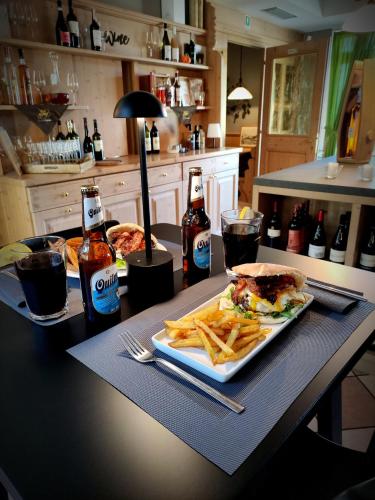 a table with a plate of food and a sandwich and french fries at Hotel Villa Argentina Ronzone in Ronzone